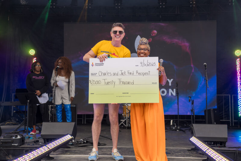 Community Foundation's Amber Burns-Jones presents a $20,000 check to Chris Hartman of the Fairness Education Fund