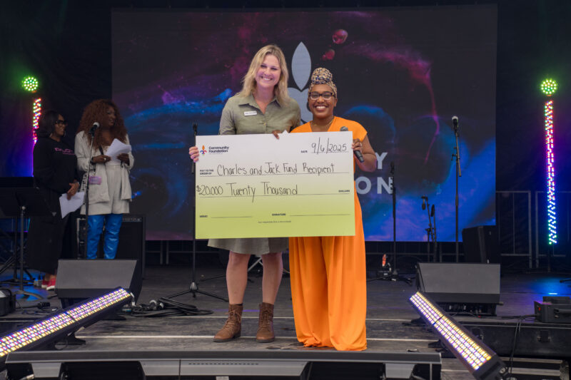 Community Foundation's Amber Burns-Jones presents a $20,000 check to Madelyn Spalding of Louisville Youth Group