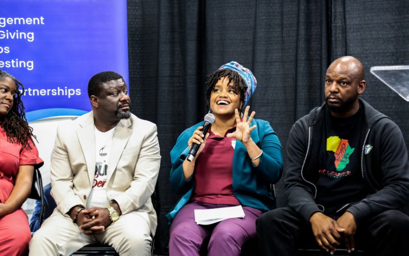 Photo featuring members of the Racial Justice Cohort speaking about their experiences at the report launch and reflection event.