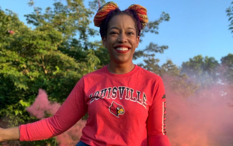 Dr. Brandy Shumake smiling and wearing her UofL sweatshirt