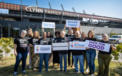 group of people smiling and holding give for good signs