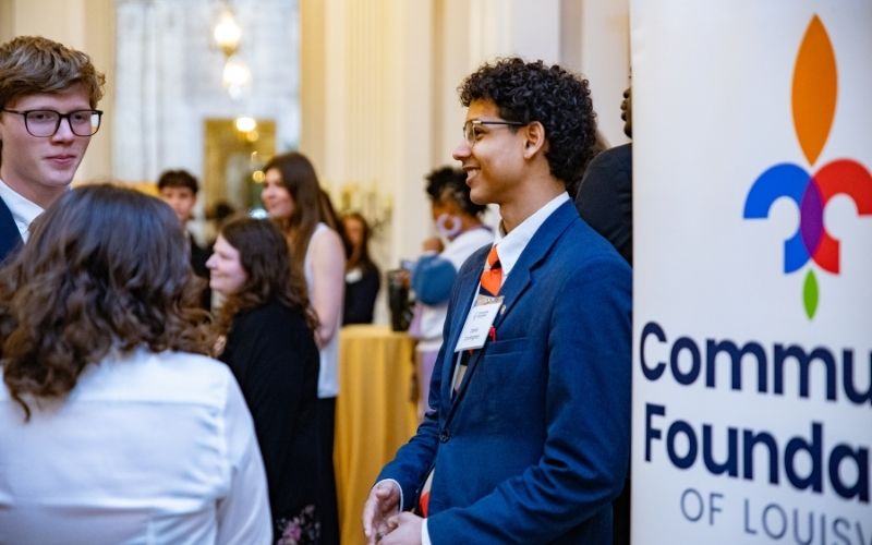 Young man smiling and talking with another young man